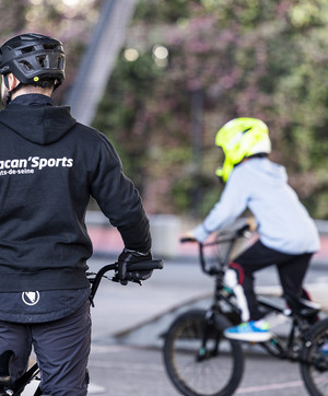 Jeune encadré par un éducateur sur l'activité BMX